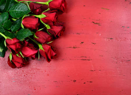 Happy Valentines Day background with red roses on distressed vintage recycled wood table.の写真素材