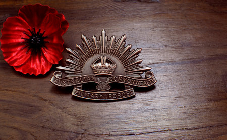 ADELAIDE, AUSTRALIA - APRIL 2, 2014: Australian Anzac WWI rising star hat badge with red poppy on vintage wood background for Anzac Day and 100th anniversary centenary of the Gallipoli Campaign in 1915.のeditorial素材