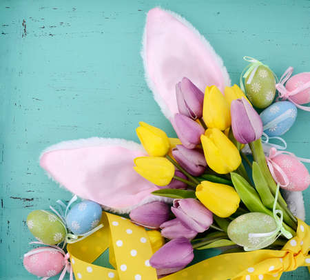 Happy Easter pink bunny ears on aqua blue wood table.の写真素材