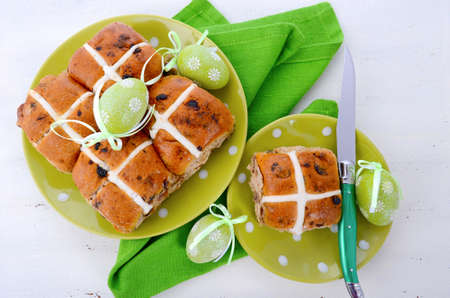 Easter Fruit Hot Cross Buns on green polka dot plate on white wood table.