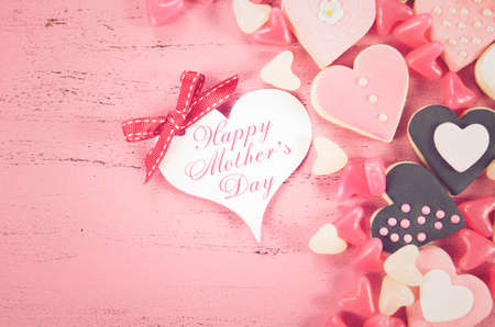 Happy Mothers Day gift of pink heart shape cookies with sample text, and applied retro vintage style filters.の写真素材