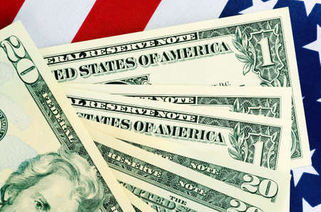 USA Tax Day, April 15, or money, savings and finance concept with calculator and USA dollar notes on American flag, with serial numbers removed.の写真素材