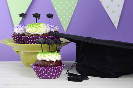 Graduation Day green and purple theme party with cupcakes and graduation cap toppers.の写真素材