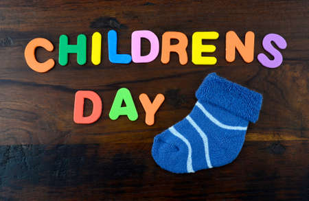 Happy Childrens Day concept with colorful play letters and decorations on dark wood rustic table.の写真素材