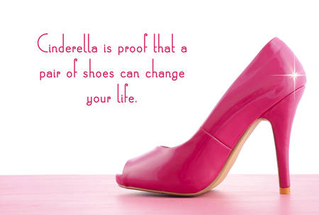 Pink high heel shoe on pink wood shabby chic table with Cinderella Is Proof quote.の写真素材