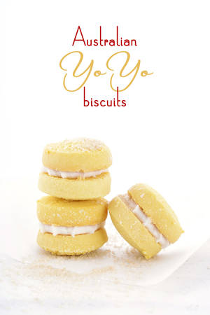 Stack of traditional Australian style yo-yo biscuit cookies on white paper on shabby chic table.