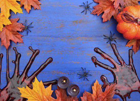 Halloween rustic blue wood background with bloody hand prints and decorations, with copy space for your text here.の写真素材