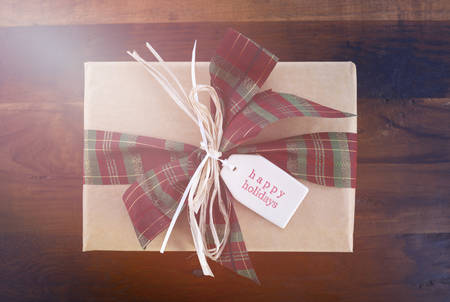 Vintage style Christmas gift on dark wood background with added retro vintage style filters and lens...