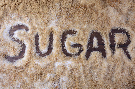 The word, sugar, written in various types of sugar including white, brown, dark brown, demerara,and coffee sugar crystals.の写真素材