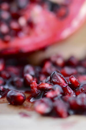 Autumn harvest fruit, pomegranates, on rustic wood background, with macro closeup on seeds.の写真素材