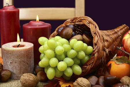 Happy Thanksgiving table setting in classic rustic colors on wood table with cornucopia centerpiece,...