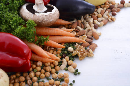 Vegetarian food including vegetables, nuts and legumes with copy space on white background.の写真素材