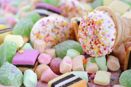 Bright colorful candy on pale blue wood table closeup.