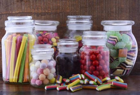 Happy Halloween Candy in Glass Apothecary Jars on dark wood table.の写真素材