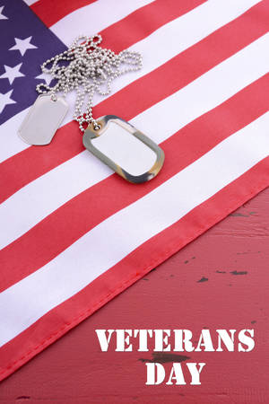 Veterans Day USA flag with dog tags on rustic red wood background with sample text.の写真素材