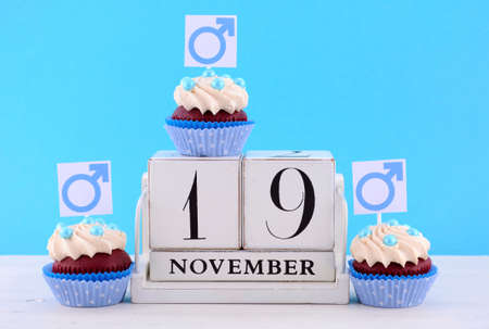 International Mens Day Cupcakes with Male Symbols with vintage wood calendar for November 19 on pale blue and white wood background.の写真素材