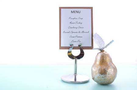 Blue, White and Gold Thanksgiving table with gold pear ornament and Pumpkin Soup, Roast Turkey and Pecan Pie listed on a menu stand.の写真素材