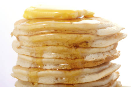 Stack of pancakes closeup, with drizzling honey syrup.