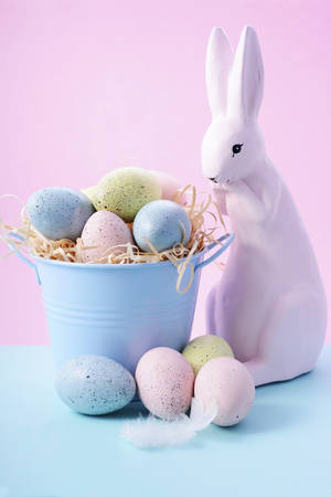 Cute Easter Bunny with bucket of eggs in pink and pale blue pastel colors.