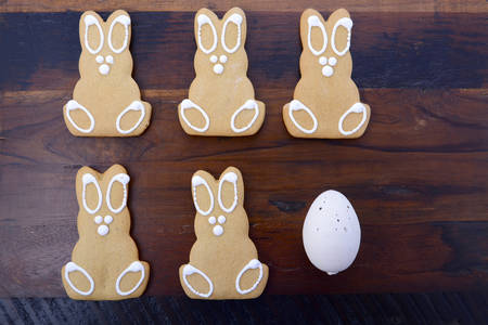 Happy Easter gingerbread cookie bunnies on a dark wood table background.の写真素材