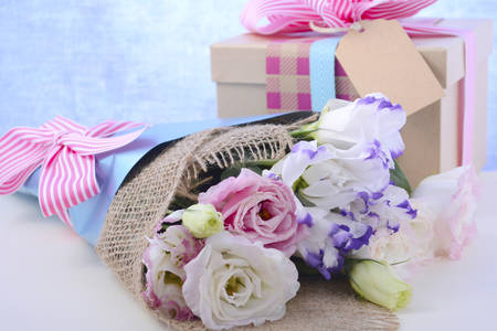 Beautiful Mother's Day lisianthus flowers wrapped in burlap and blue paper with gift box on white...