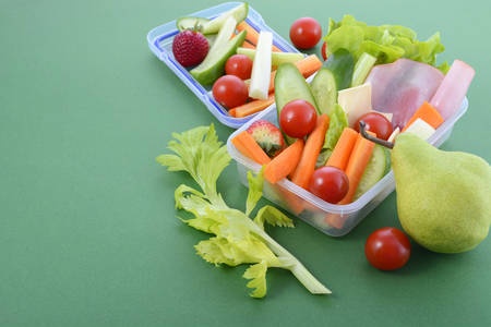 Back to school healthy school lunch box on green background with copy space.の写真素材