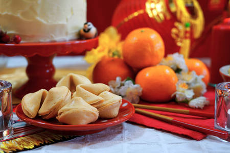 Chinese New Year party table in red and gold theme with food and traditional decorations.の写真素材