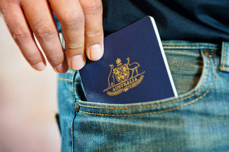Australian passport in mans jeans pocket, close up.の写真素材