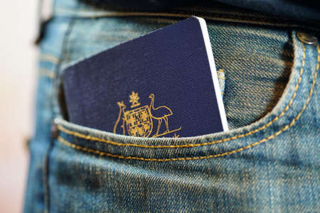 Australian passport in mans jeans pocket, close up.の写真素材