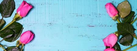 Vintage aqua blue wood background with decorated borders of pink rose buds with copy space and room for text.の写真素材
