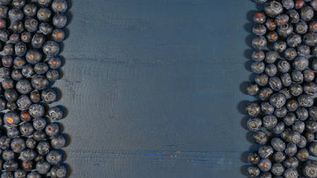 Blueberries on dark blue rustic wood table overhead, with copy space.の写真素材