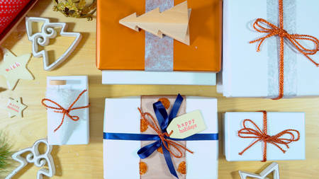 Wrapping Christmas gifts overhead with finished gifts laid out.