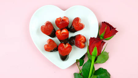 Happy Valentines Day overhead flat lay with heart shaped strawberries dipped in chocolate.の写真素材