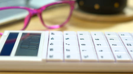 Close up of modern calculator with glasses and coffee, shallow DOF.の写真素材