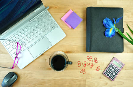 Office desk with modern touch screen pc, diary planner, and morning coffee.