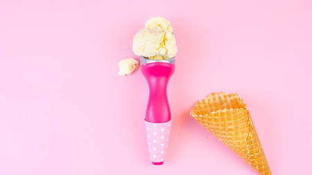 Ice cream cones and scoop overhead flat lay on pink wood table.の写真素材