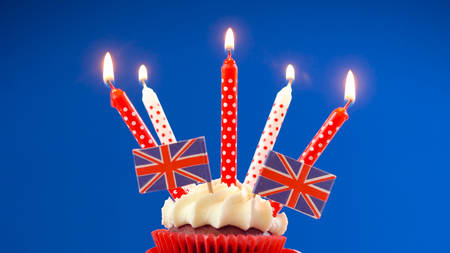 Red white and blue theme cupcakes and cake stand with UK Union Jack flags for Queens Birthday weekend celebration or Great Britain party food.の写真素材