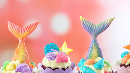Mermaid theme cupcakes with colorful glitter tails, shells and sea creatures toppers for children's, teen's, novelty birthday and party celebrations.の写真素材