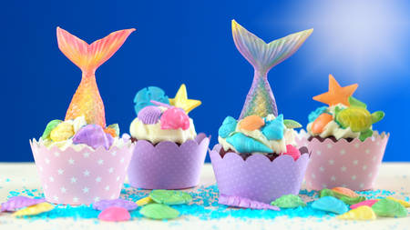 Mermaid theme cupcakes with colorful glitter tails, shells and sea creatures toppers for children's, teen's, novelty birthday and party celebrations.の写真素材