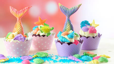 Mermaid theme cupcakes with colorful glitter tails, shells and sea creatures toppers for children's, teen's, novelty birthday and party celebrations.の写真素材