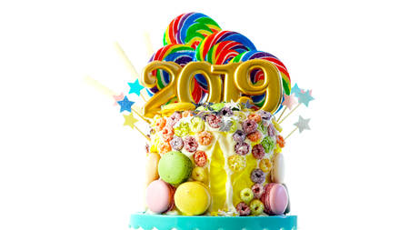 Happy New Years candy land lollipop drip cake with 2019 candles on white background.の写真素材