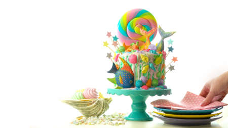 Mermaid theme candyland cake with colorful glitter tails, shells and sea creatures toppers for childrens, teens, novelty birthday and party celebrations.の写真素材