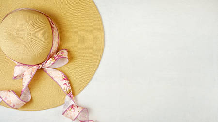 Female sunhat with beautiful floral ribbon on white background with copy space.