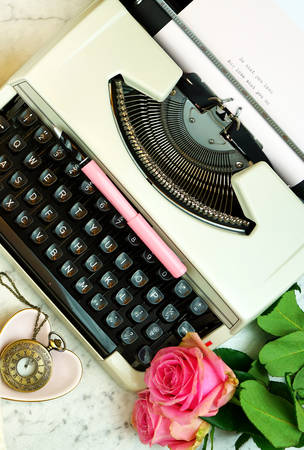 Romantic vintage feminine writing scene, tea break with old typewriter and pink roses on marble table top down overhead.の写真素材