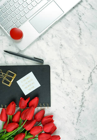 Modern stylish feminine desk or workspace coffee break with high tech touchscreen laptop and red female accessories, with copy spaceの写真素材