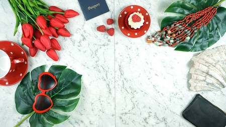 Summer vacation concept flatlay with red feminine accessories on white marble background with copy space.の写真素材
