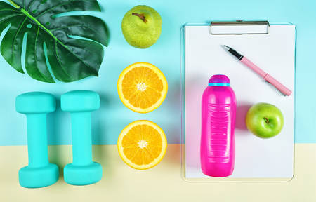 Health and fitness concept flatlay with exercise equipment on modern colorful background.の写真素材