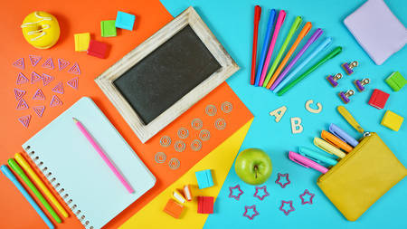 Back to school colorful kids theme concept flat lay with blackboard, notebook, stationery and apple for the teacher.の写真素材