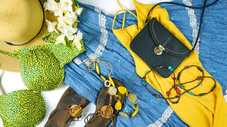 On-trend Boho Chic style fashion layout flat lay with blue and yellow theme bohemian skirt, sandals, and accessories.の写真素材