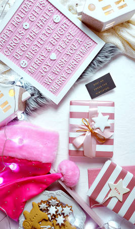 On-trend stylish Christmas flat lay, cozy in bed or indoors wrapping gifts with warm sweater, gifts and letter board.の写真素材